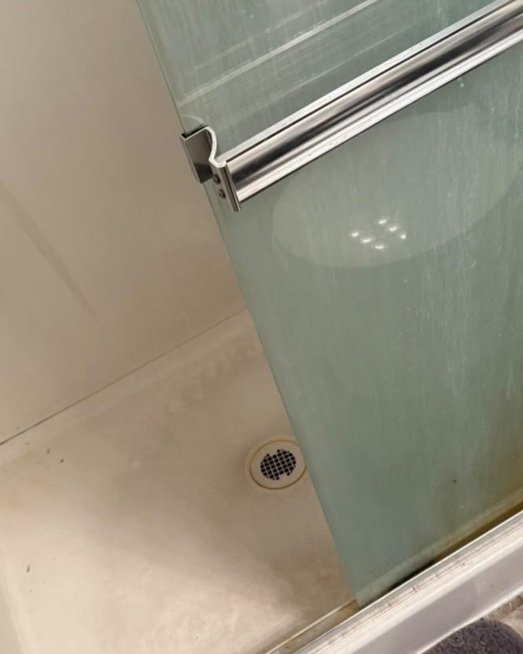 Shower door and pan before cleaning, soap scum and grime