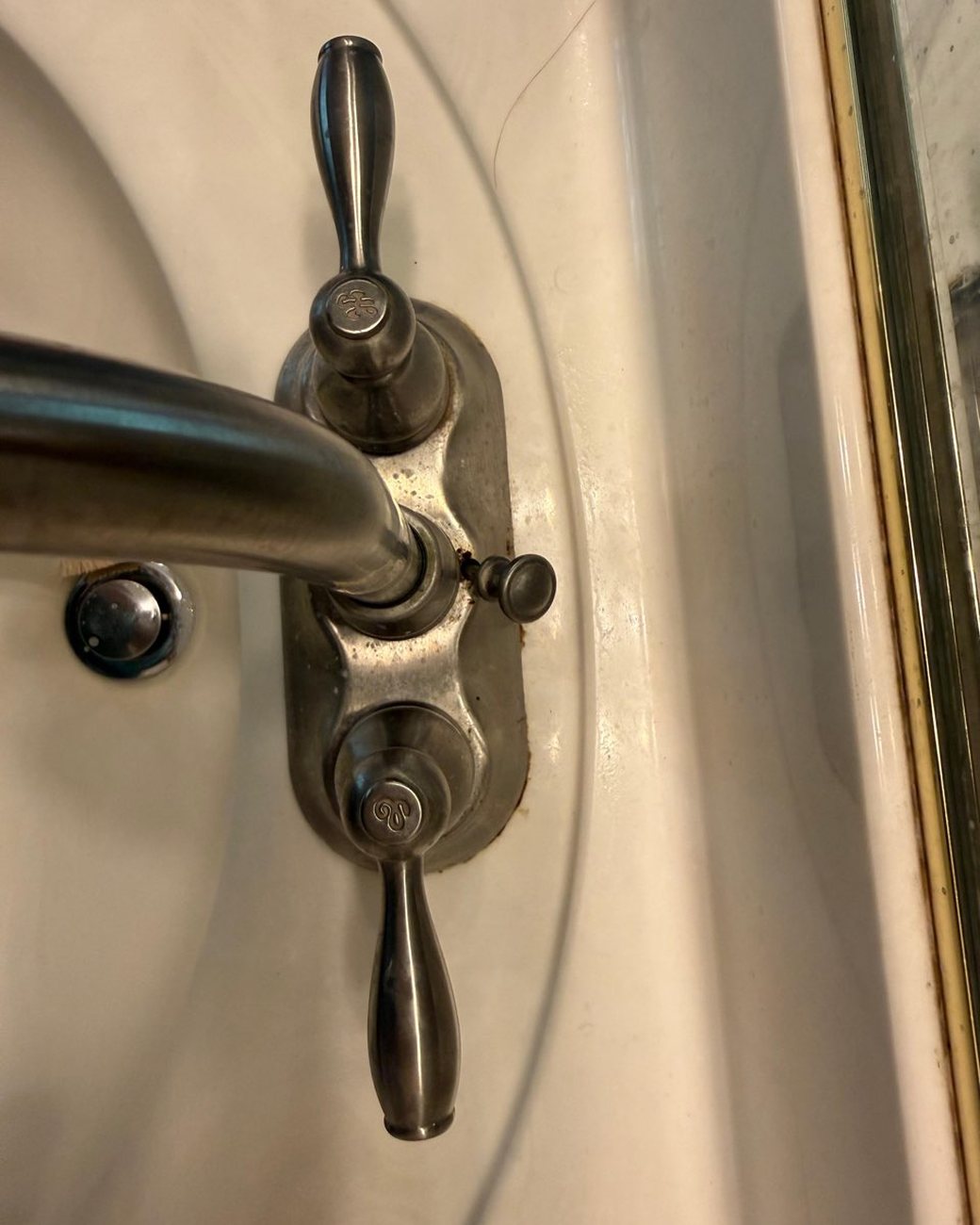 Sink faucet before cleaning, tarnished with grime
