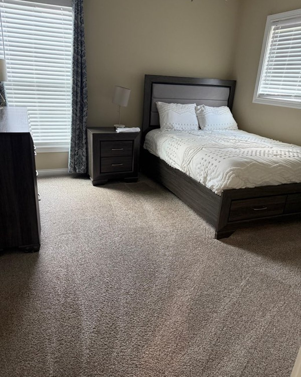 Tidy bedroom with fresh carpet after cleaning