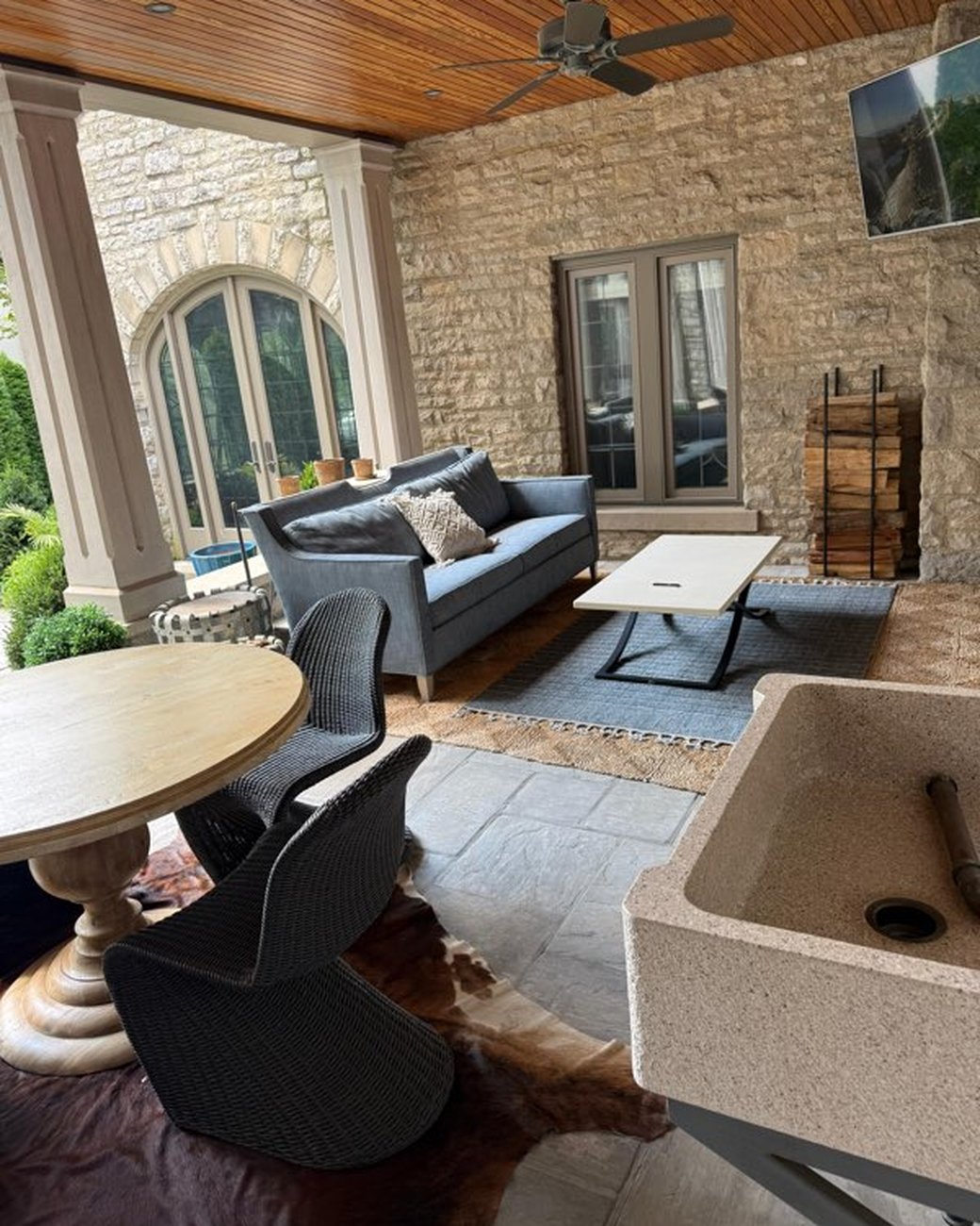 Clean outdoor patio living area with stone walls